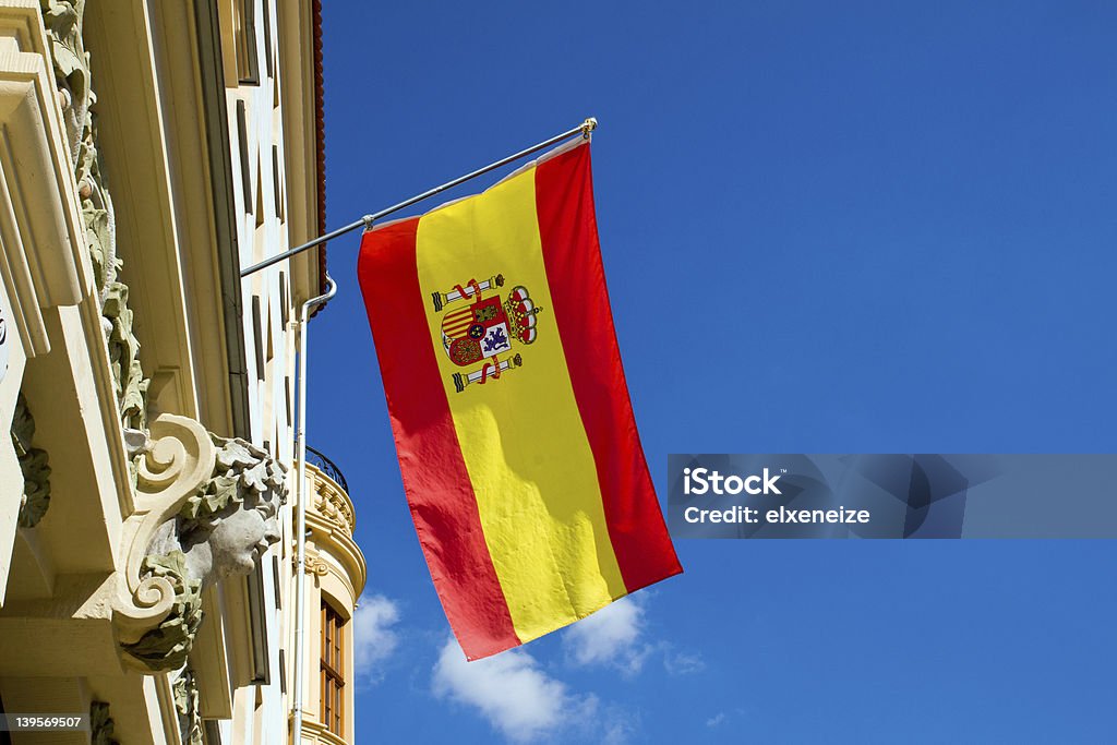 Spanish flag flying at an old building Spanish flag flying at an old building in front of a blue sky Blue Stock Photo