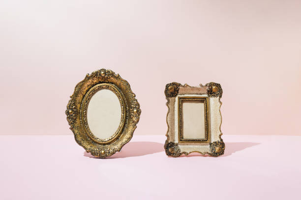 istock Two vintage golden picture frames, oval and rectangular on pink background. Minimal concept. 1395696143