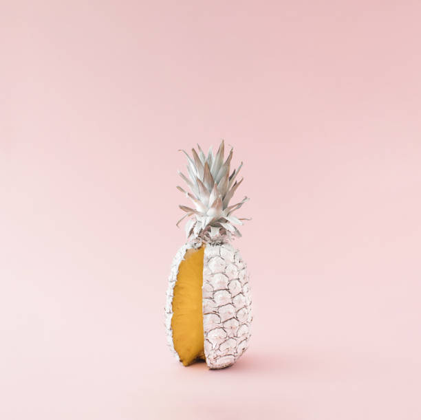 istock Fresh pineapple colored in white with one cut slice. Minimal summer food concept idea. 1395696249
