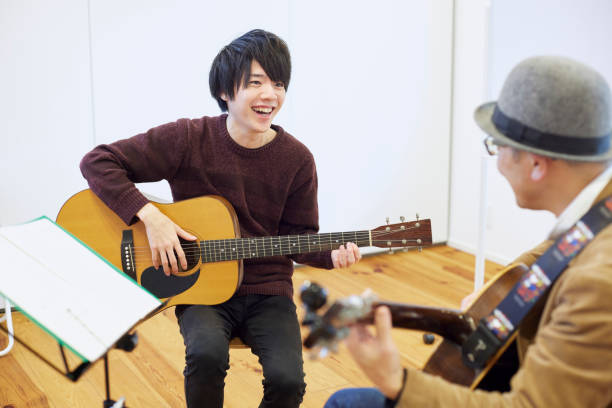 istock Japanese man playing the guitar 1395696385