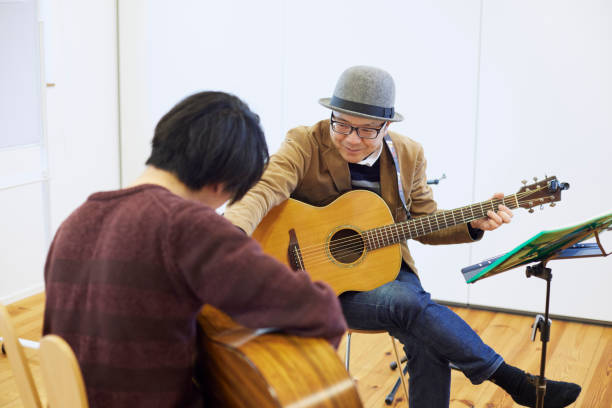 istock Japanese man playing the guitar 1395696386
