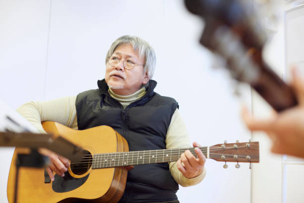 istock Japanese man playing the guitar 1395696405