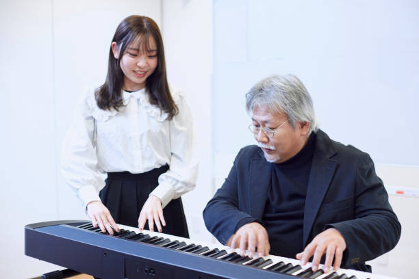 istock A young woman teaching the piano and a man teaching 1395696416