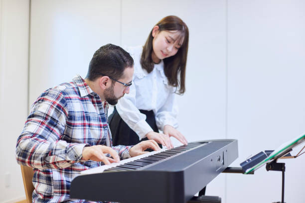 istock A young woman teaching the piano and a man teaching 1395696436