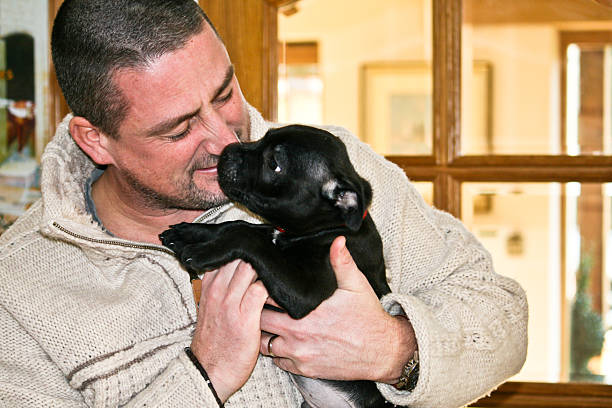 istock Man Cuddling Puppy 139569646