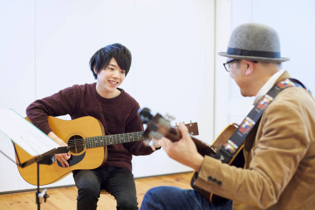 istock Japanese man playing the guitar 1395697335
