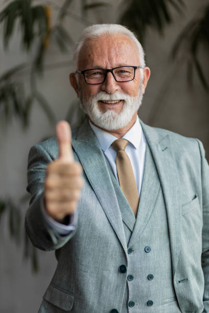 istock Senior man in a full suit, with thumbs up 1395697338