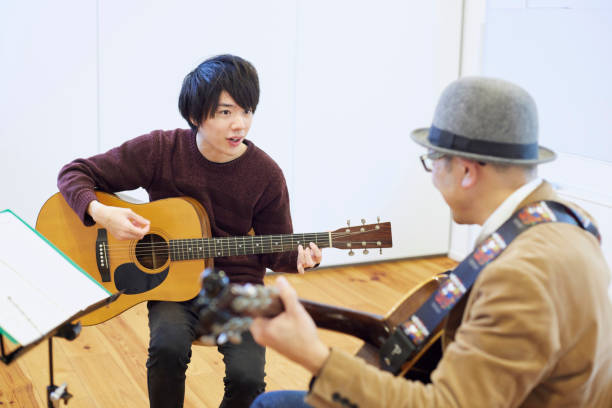 istock Japanese man playing the guitar 1395697492
