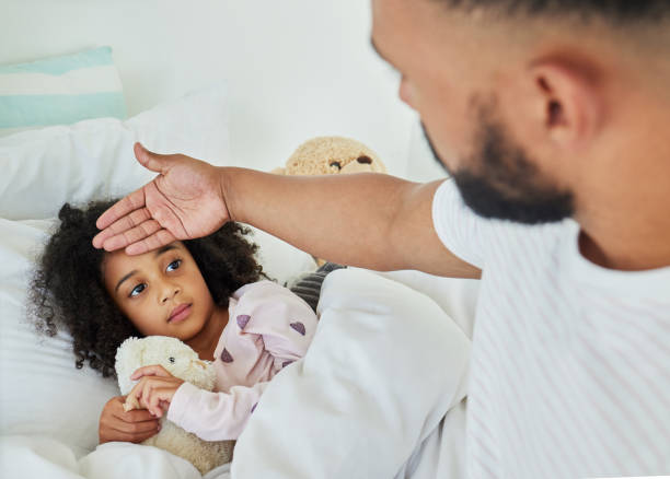 Shot of a young father looking after his sick daughter at home It's okay if you're not feeling well fever stock pictures, royalty-free photos & images