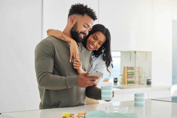 istock Shot of a young couple using a phone while drinking coffee at home 1395698401