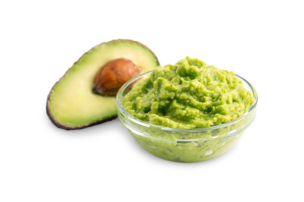 Mexican organic guacamole dipping sauce made of pureed avocado served in bowl isolated on white background Healthy homemade mexican dip, sauce or spread made of mashed ripe green raw avocado served in glass bowl with ingredient as snack for drop guacamole stock pictures, royalty-free photos & images
