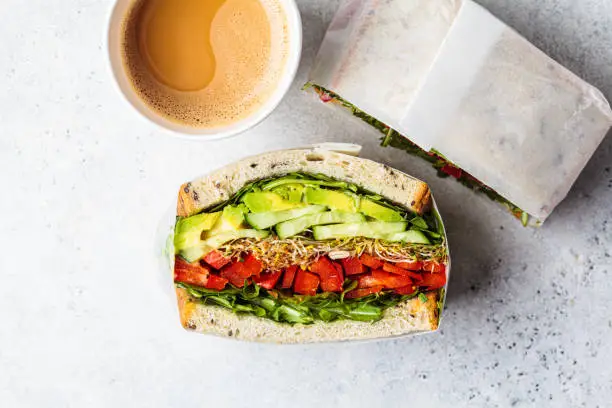 Vegetable sandwich in paper bag, top view. Vegan healthy food, takeaway food.
