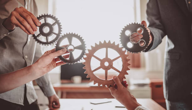 istock Group of people working in the office while putting together cogwheels. 1395704709