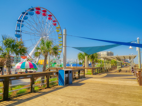 A nice summer view of the romantic wooden boardwalk at the Carolina Beach Amusement Park in Wilmington, NC.