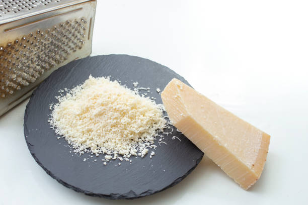 grated parmesan on a black stone tile, isolated on white background. copy space for text
