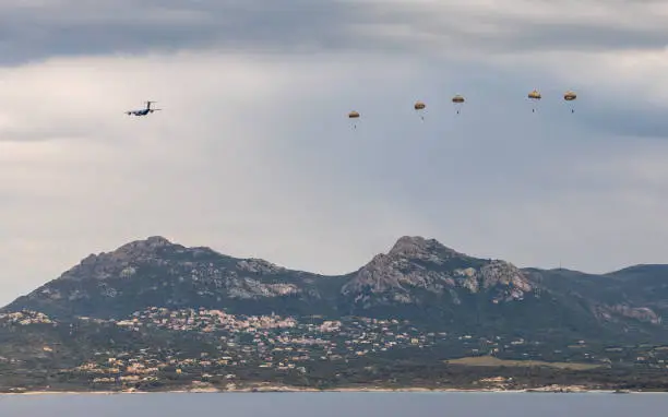 The 2nd Foreign Parachute Regiment (2e REP) of the French Foreign Legion jump from a French Air Force plane in training over the bay of Calvi in Corsica with the village of Lumio in the distance
