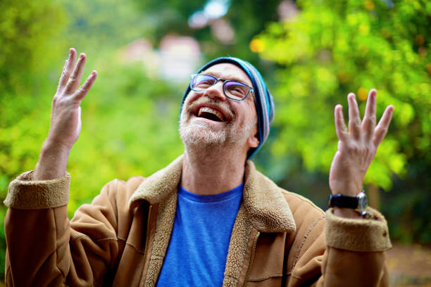 White middle-aged man with a knit hat and glasses looks satisfied