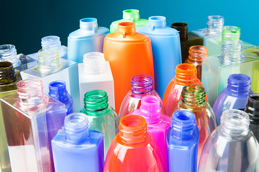 Group of empty coloured plastic bottles and containers for detergents and chemicals. Concept about plastic recycling or chemical pollution