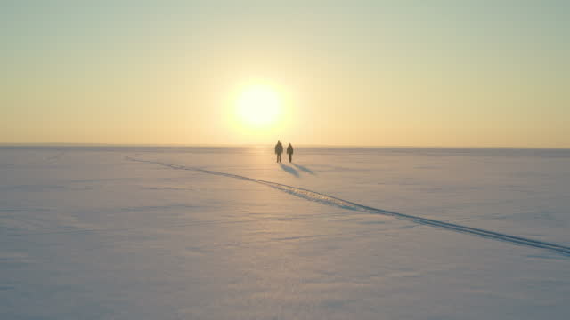 The man and woman trekking through the icy snow field
