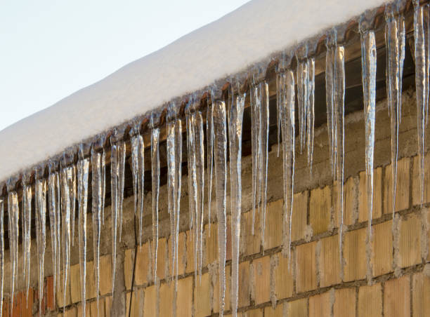 Icicles hang from the roof of the house. stock photo
