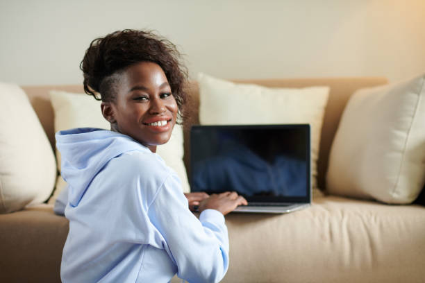 istock Smiling Woman Typing on Laptop 1395724257