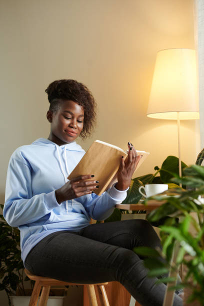 istock Young Woman Reading Novel 1395724338
