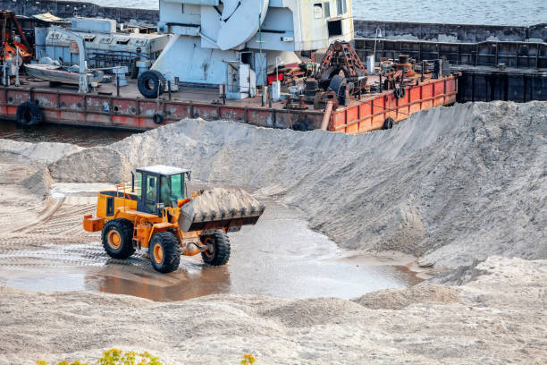 bulldozer mit sand in einer schaufel - industrial ship earth mover barge yellow stock-fotos und bilder