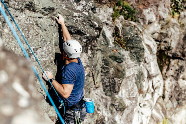 istock Top view of a man climbing all the way up, using all his strength. 1395727107