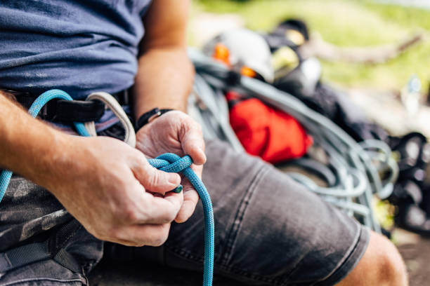 istock Active man showing off his technique of tying a rope for climbing. 1395727116