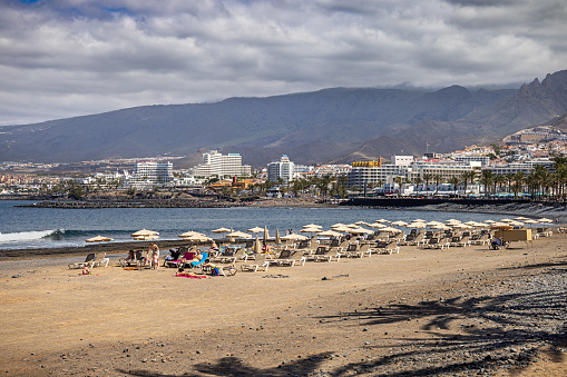 Beach chairs with hotels in the background at Playa de las Americas which is a popular tourist location on the south coast of the the Spanish Canary Island Tenerife.