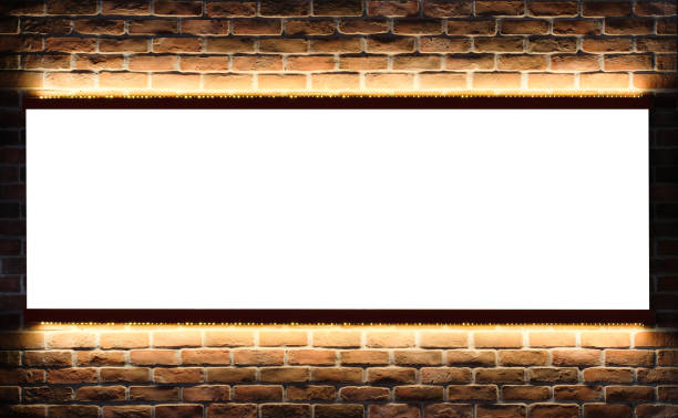 istock Billboard mock up on brick wall with LED light. Template of an interior empty information billboard, Mock-up of a banner placeholder and poster. 1395729034
