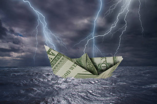 istock Paper boat made from a One Dollar note almost capsizes in high waves 1395730705