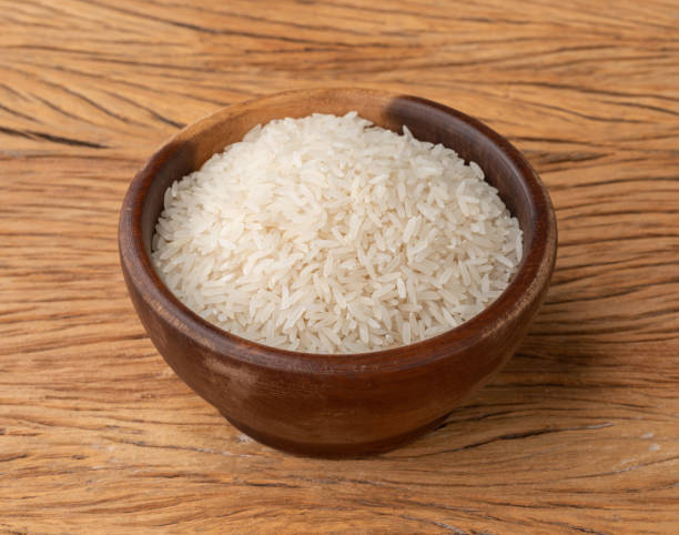 istock Raw white rice in a bowl over wooden table 1395732203