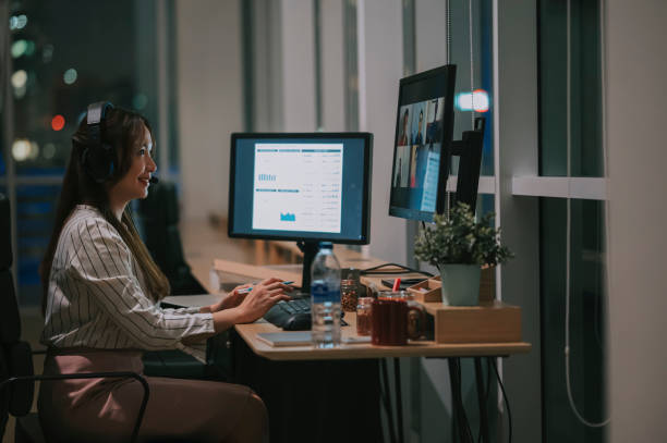 istock Asian Chinese female white collar worker video call working late in office alone in low light 1395732230