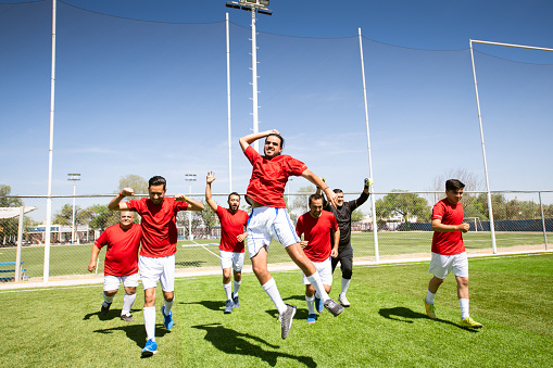 Soccer team celebrating victory on soccer field