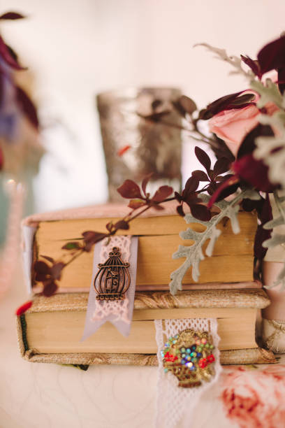 istock Table setting at country wedding reception, wedding floral decoration and wrapped books. 1395733723