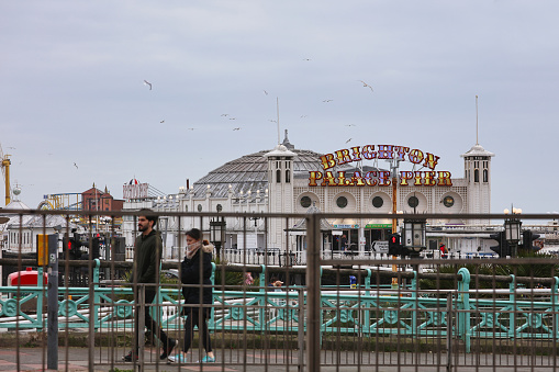 Brighton, United Kingdom - Feb 23, 2022: Brighton Palace Pier is frequented by tourists on February 23, 2022, in Brighton, United Kingdom.