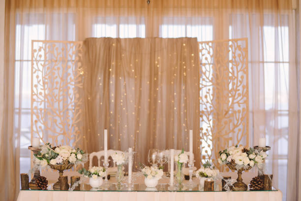 istock Table setting at winter wedding reception, floral composition, candles and cones, lights on the background. 1395733729