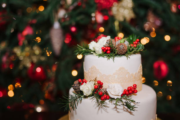istock Wedding cake decorated with cones, pine, flowers and berries at winter reception on the background of Christmas tree. 1395733765
