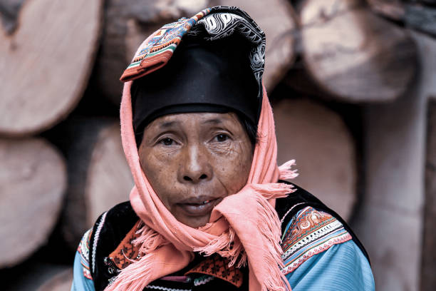 Portrait of Laotian woman, wearing traditional Lantan tribe clothes in a Lantan village in Northern Laos.The Lantan tribe is famous for deep blue hand-woven and hand dyed cotton fabrics, so woman's hands are also blue.