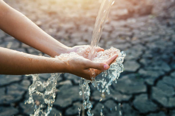 wasser, das im morgenlichen hintergrund auf die hand strömt - hohle hände stock-fotos und bilder