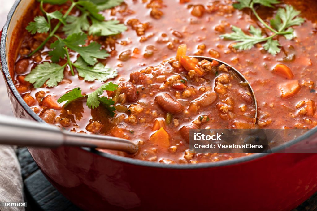 Traditional chili soup with meat and red beans Traditional chili soup with meat, vegetables and red beans in a dutch oven with a ladle Chili Con Carne Stock Photo