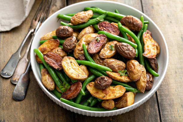 roasted crispy fingerling potatoes with green beans n a serving bowl - fingerling imagens e fotografias de stock