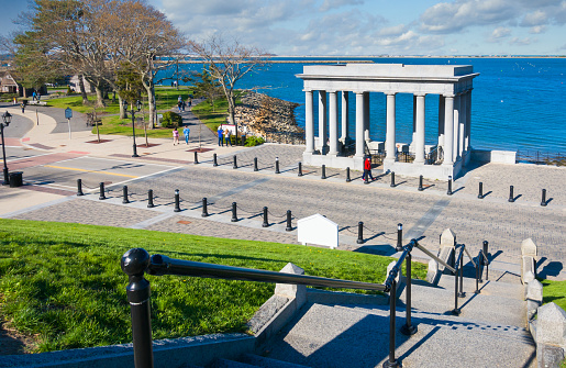 Plymouth, Massachusetts, USA- May  1, 2022- Stone stairs lead down a hill where visitors enter the columned memorial housing the rock where pilgrims supposedly first stepped foot onto a new colony in 1620.  The monument was erected on the 300th anniversary of the event.