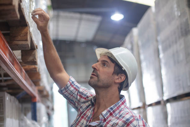 istock Manager wearing protective helmet and checking racks at distribution warehouse 1395740164