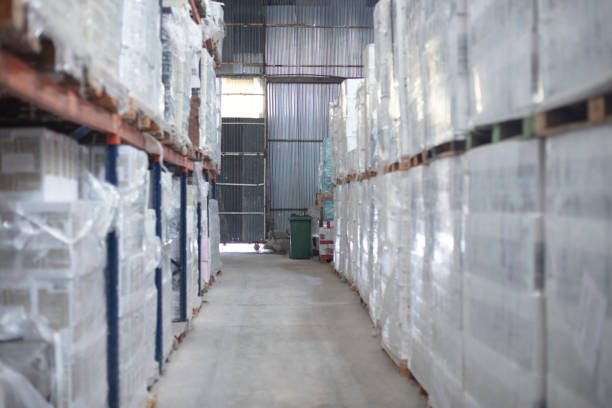 istock Empty distribution warehouse aisle full of stacked pallets 1395740211
