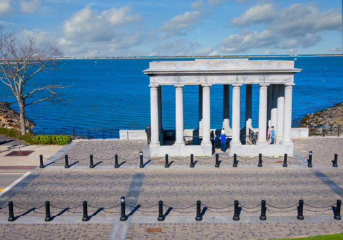 Plymouth, Massachusetts, USA- May  1, 2022-  Visitors enter the columned memorial housing the rock where pilgrims supposedly first stepped foot onto a new colony in 1620.  The monument was erected on the 300th anniversary of the event.