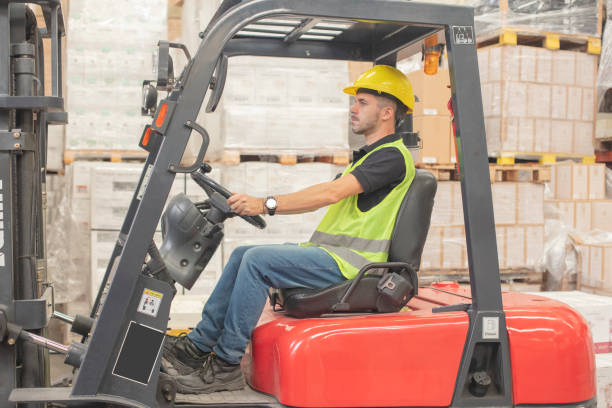 istock Employee wearing protective workwear and getting on forklift at distribution warehouse 1395740807