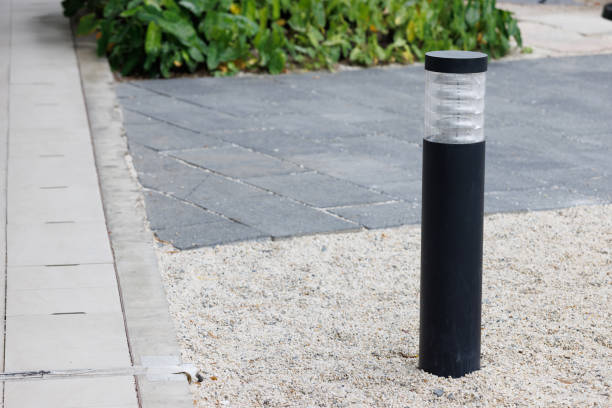 black light bollard on stone floor in garden near pavement.