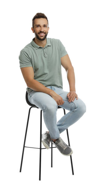 istock Handsome man sitting on stool against white background 1395742078